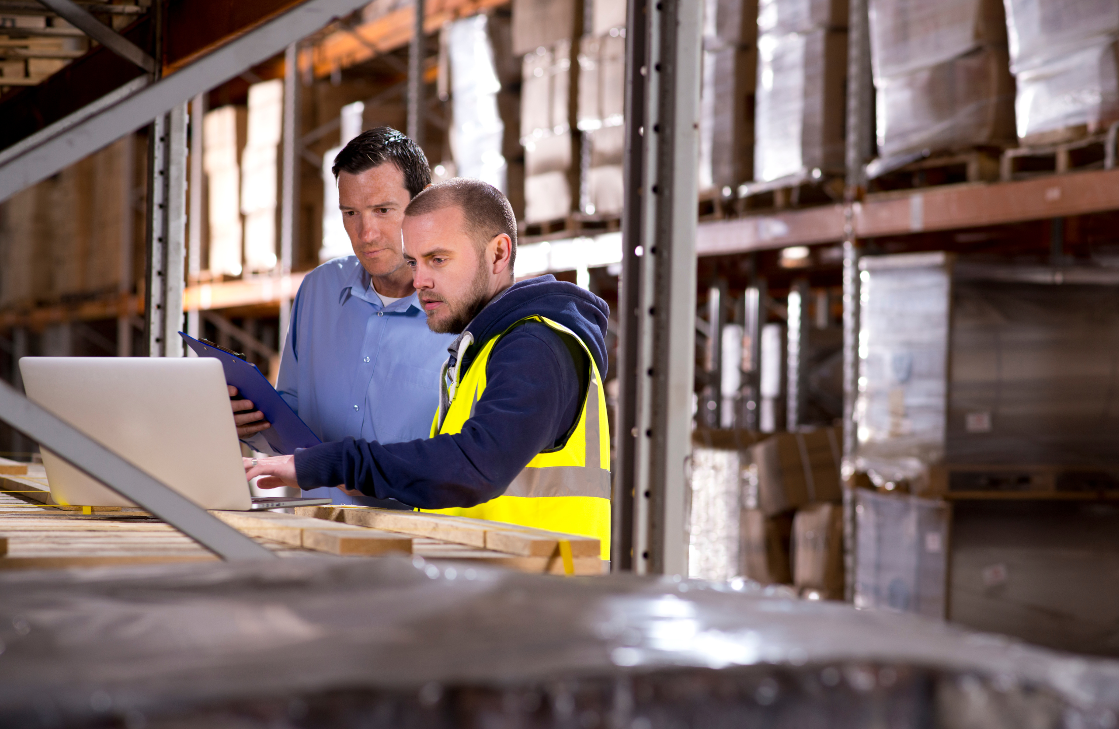 WorkGuru | What Level of Detail Should I Manage My Stock? Warehouse manager and worker reviewing stock levels