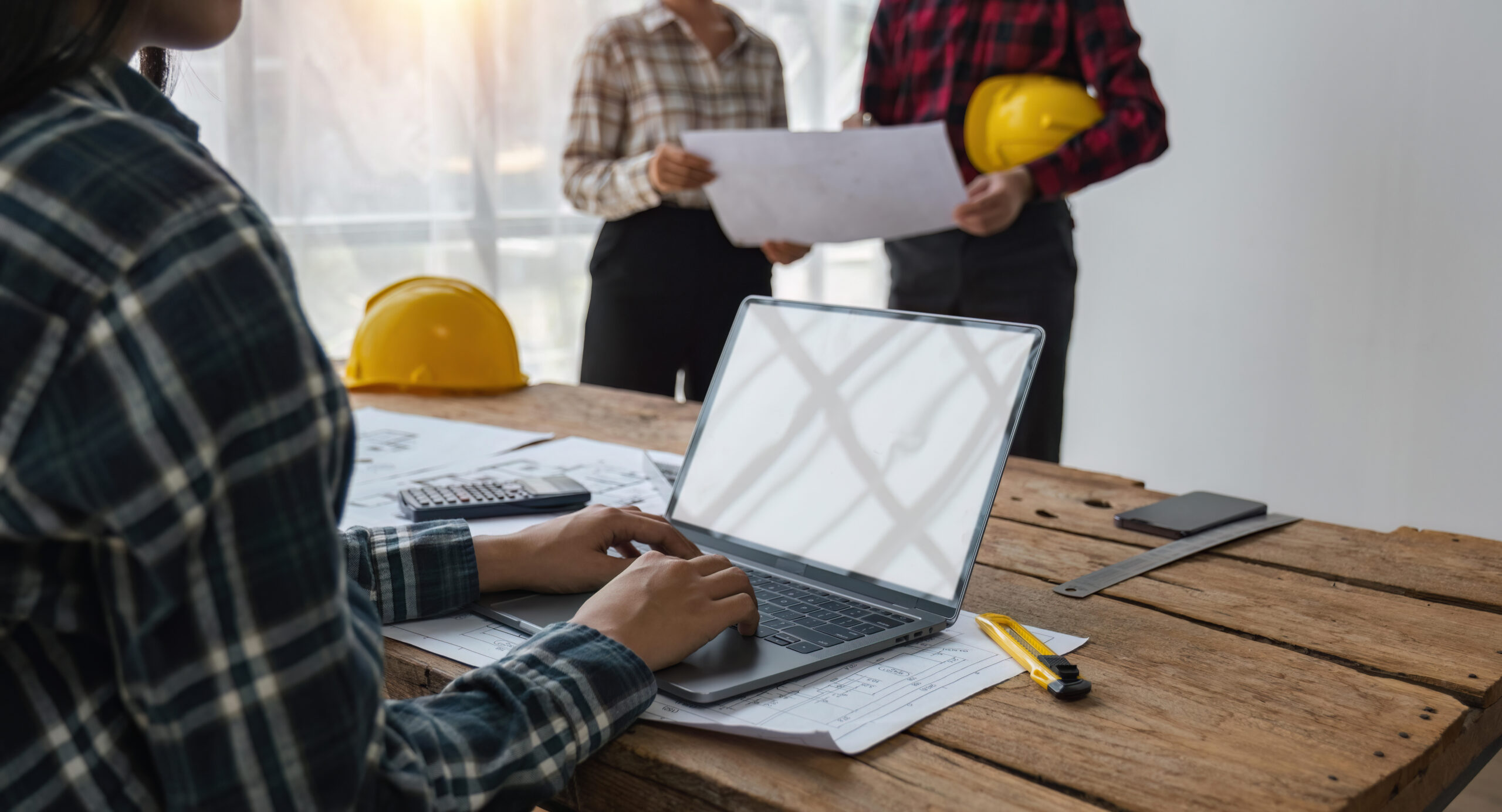 WorkGuru | The True Cost of Your Stock: What Are Landed Costs and Why Do They Matter? a person using a laptop